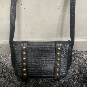 This is a designer handbag by silvano biagini black bag with gold features.